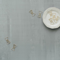 retro plate with golden clips on concrete background. flat lay, top view