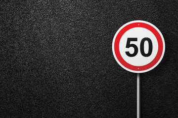 Road sign circular shape on a background of asphalt. The speed limit. The texture of the tarmac, top view.