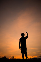 Fototapeta premium Silhouette of man and beautiful sky. hand up of success.