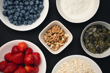 Bowls with blueberries, strawberries and oat flakes for breakfast. Photo with shallow depth of field.