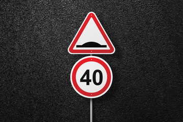 Road signs of the circular and triangular shape on a background of asphalt. Artificial roughness. Speed limit. The texture of the tarmac, top view.
