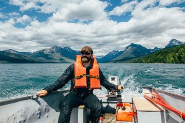 Man steering boat on Lake McDonald, Glacier National Park, Montana