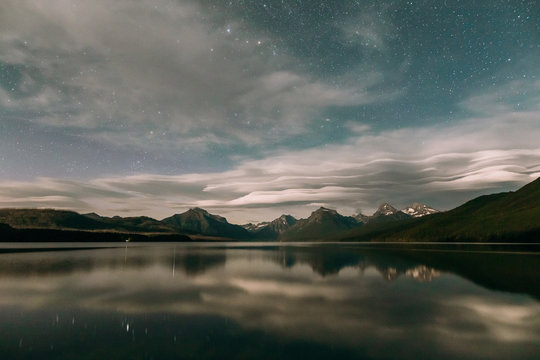 Reflection of mountain range and starry sky in Lake Mcdonald, Glacier National Park, Montana