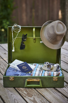 travel items including a suitcase, passport, clothing, and camera.