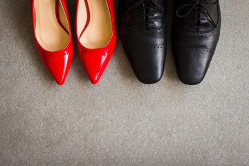 Black men shoes and red women shoes on gray background