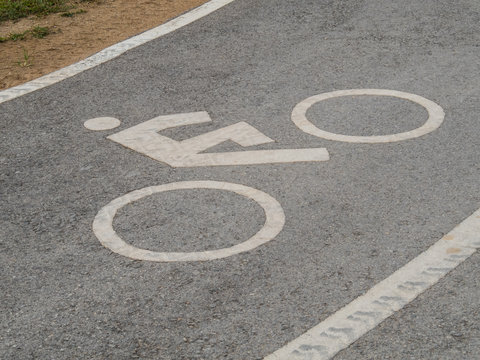 Close up of bike lane sign with car wheel track