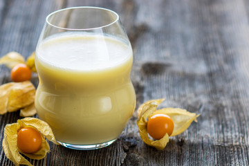 Glasses of fresh cold smoothie with fruit on wooden background