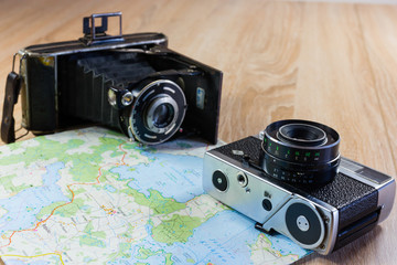 Two, old photo cameras on a paper map.