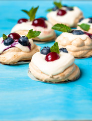 Pavlova dessert with blueberries cherries and mint
