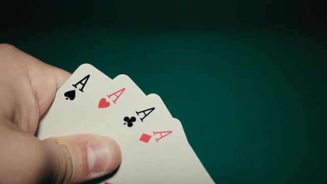 four aces in his hands on the table