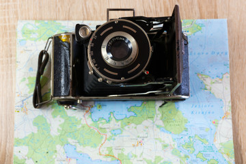 Old photo camera and paper map. Color