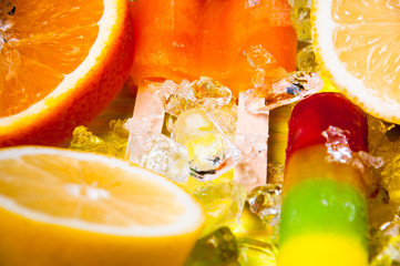 Naklejka na ściany i meble Colorful ice lolly and friuts on green wooden background