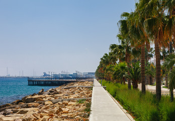 Obraz premium Coastline and promenade in Limassol, island Cyprus, Europe, Mediterranean Sea. Bright sunny day and blue water and sky.