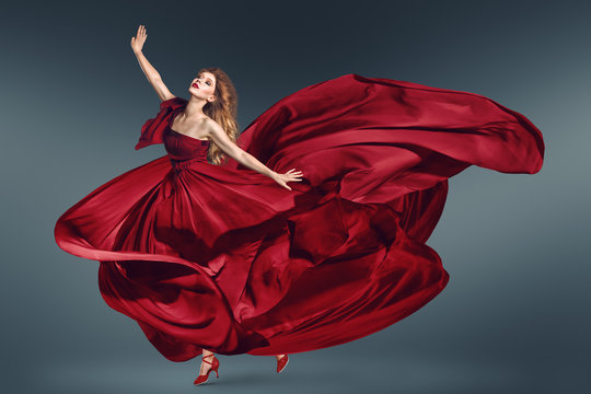 Fashion Woman Dancing In Fluttering Red Dress