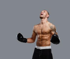 Fototapeta na wymiar Tattooed fighter isolated on a grey background.