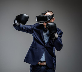 Male in a suit fighting with virtual reality glasses on his head
