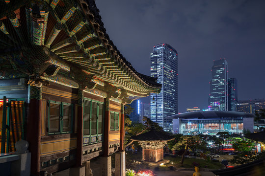 Ornate building at the Bongeunsa Temple and view of Gangnam in Seoul, South Korea at night.