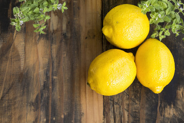 Three Lemons and Mint on a Rustic Wooden Background