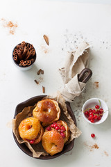 Homemade baked apples with nuts, marble syrup, cinnamon and red currant on an old pan, top view&nbsp;