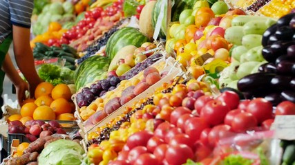 the seller arranges fruits on display