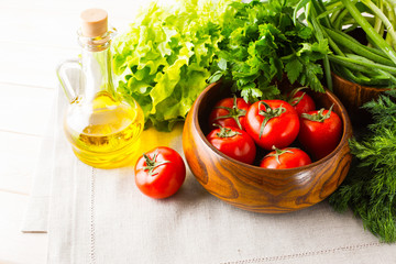 Vegetables and olive oil on the white wooden background