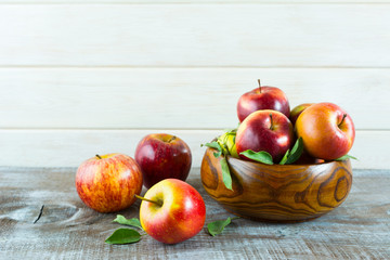 Apples in wooden bowl on the rustic background