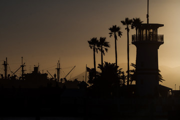 Silhouette of a light house and ship in the background © jmic2091