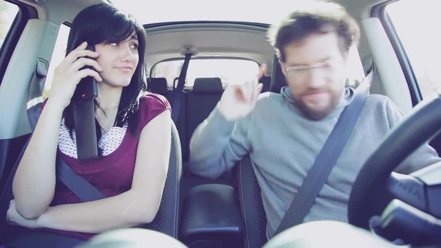 Woman looking strange boyfriend dancing in car while driving