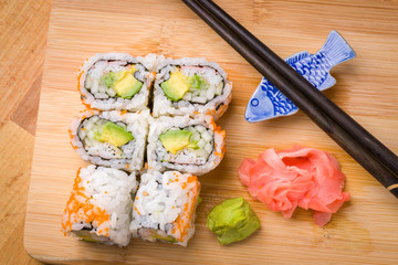 Sushi California rolls appetizer with rice avocado with chopstic