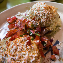 two styles of western egg benedicts on stacked tortillas with salsa
