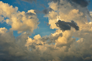 Cumulus sunset clouds with sun setting down