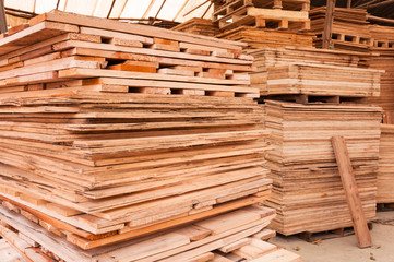 Plywood of different sizes lie on racks and pallets
