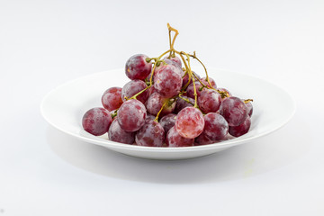 Red grapes on a white background.