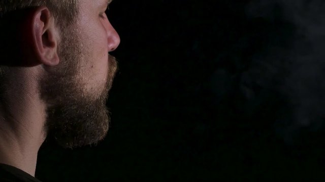 Video as a man smokes a big cigar. Black. Close up