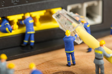 Technician team fixing cable connection wire with human miniature