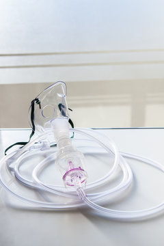 Oxygen mask for asthma treatment on table at hospital room.