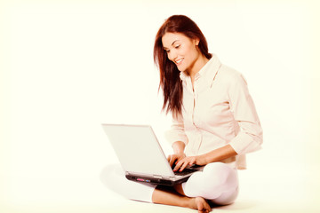 Fototapeta premium Smiling young woman sitting at a floor and she working with laptop.