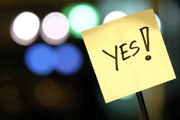 The concept of voting, signboard with the word Yes! on abstract light background