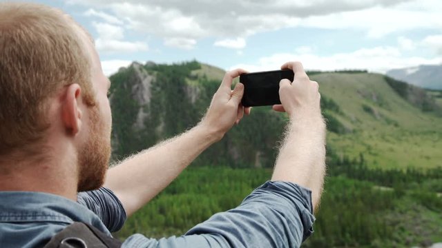 Man using smart phone take a photo mountain view