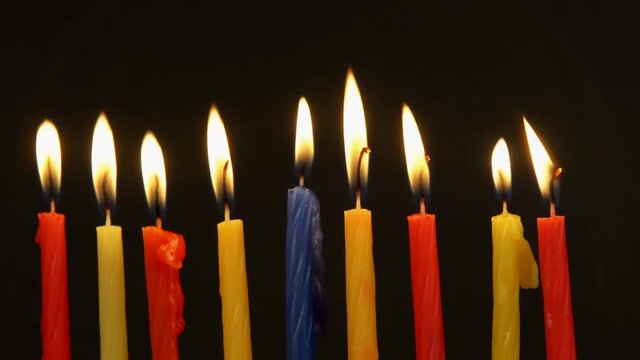 Chanukah candles all in a row. Bright, shiny multicolor candles for the Jewish holiday.