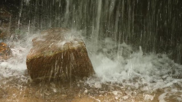 滝に打たれる石