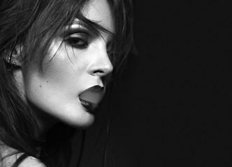 Beautiful sexy brunette girl with bright makeup, red lips, smoke from mouth. beauty face. Black and white