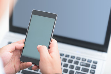 Businessman using smart phone and laptop.