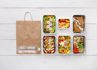 Healthy food take away in boxes, top view at wood