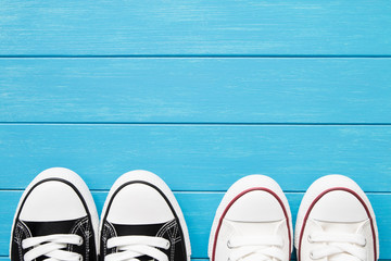 Two pairs of canvas shoes on a blue wooden