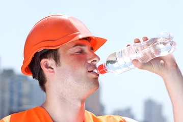 Engineer with safety vest drinking water