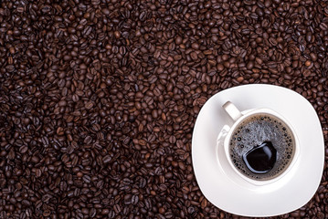 coffee beans background and white cup with hot drink