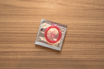 Fototapeta na wymiar sealed condom on wooden background