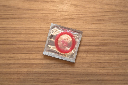 sealed condom on wooden background