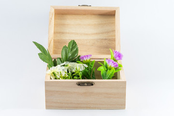 Small Wooden box opened with fake flowers isolated on white background.